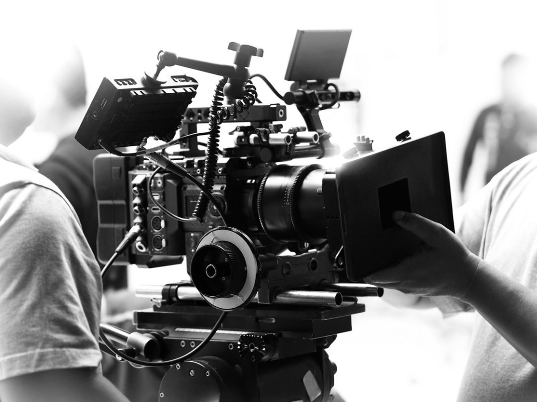 Movie shooting or video filming production by crew team and professional equipment such as super ultra high definition digital camera with tripod and lighting set in studio and black and white styles.